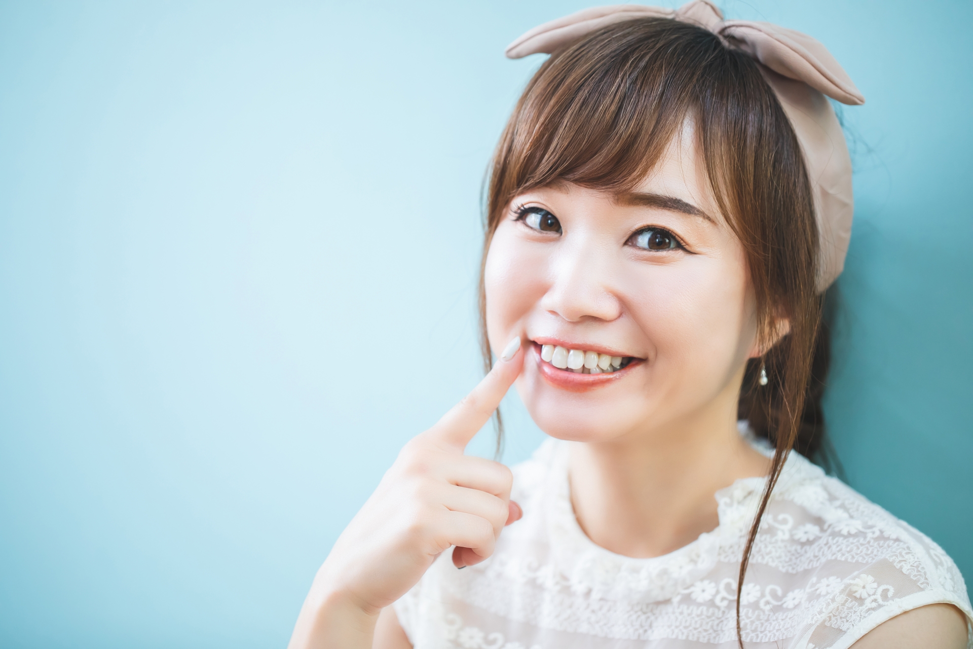 笑顔で歯を指さす女性