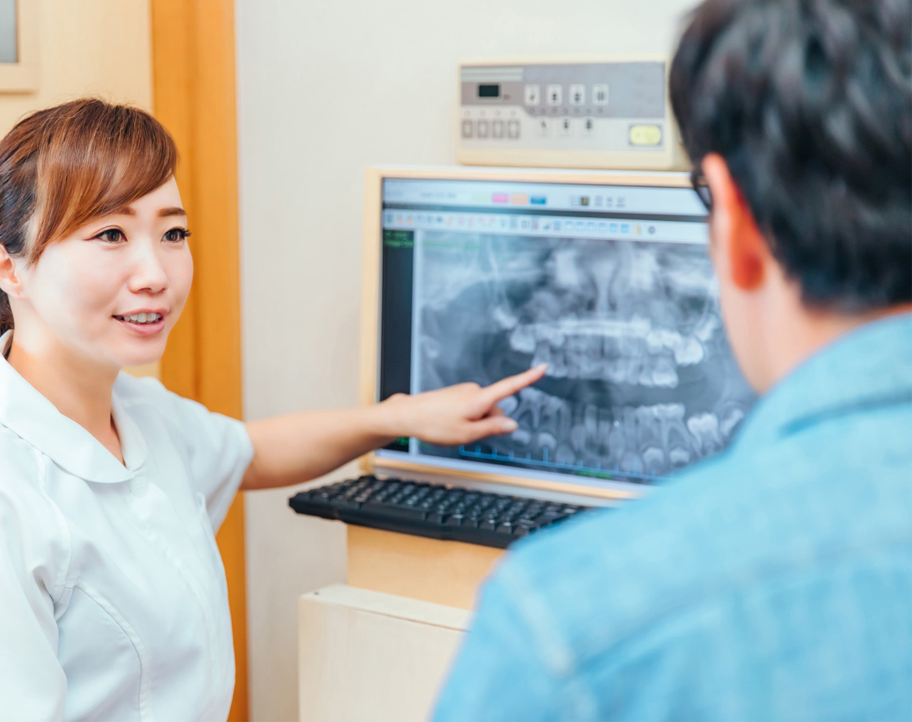 歯のレントゲンを説明する歯科衛生士