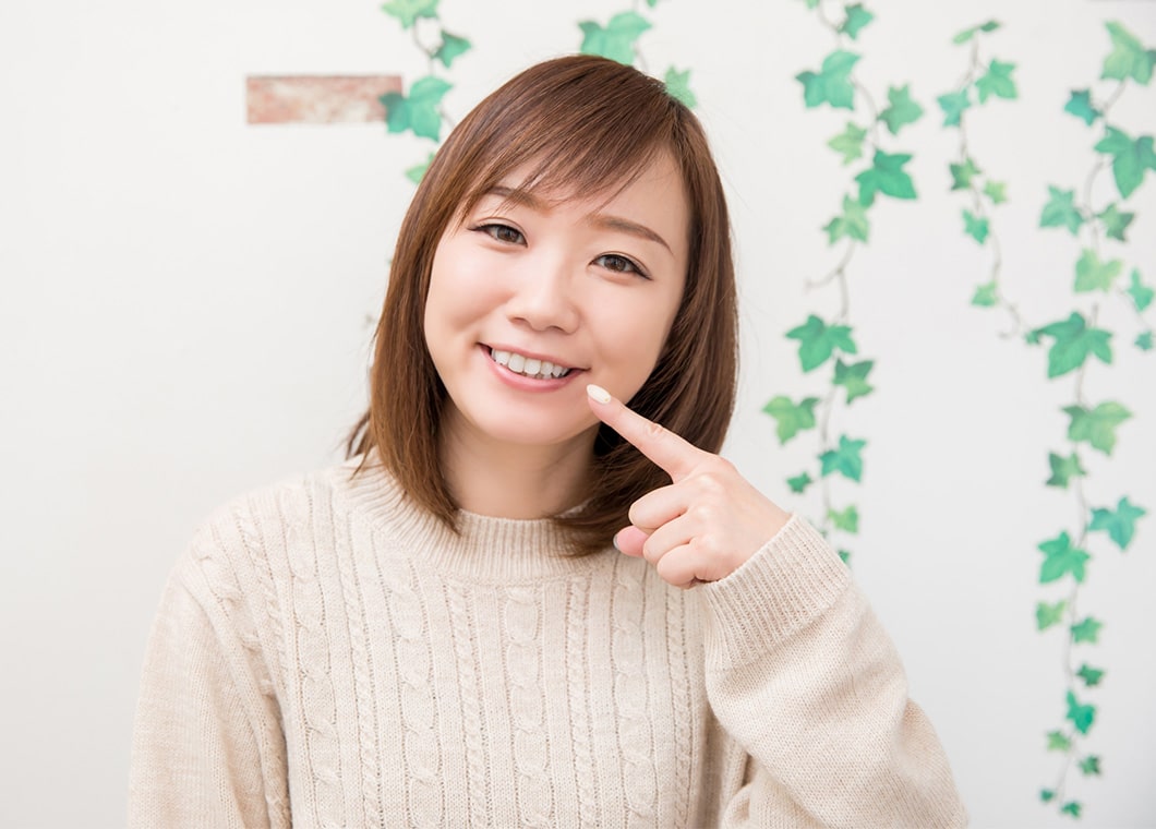 歯を指さす女性